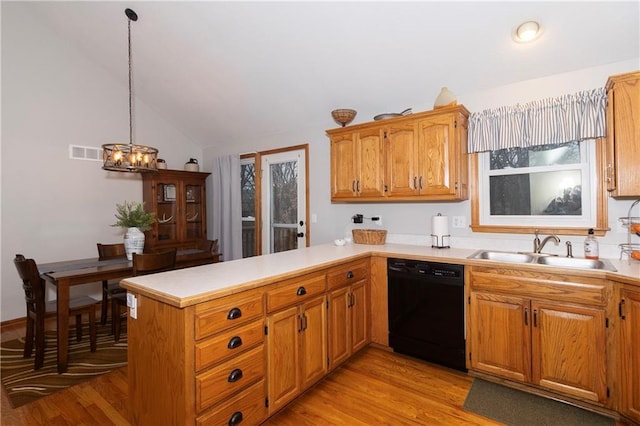 kitchen featuring light wood-style flooring, a sink, black dishwasher, a peninsula, and light countertops