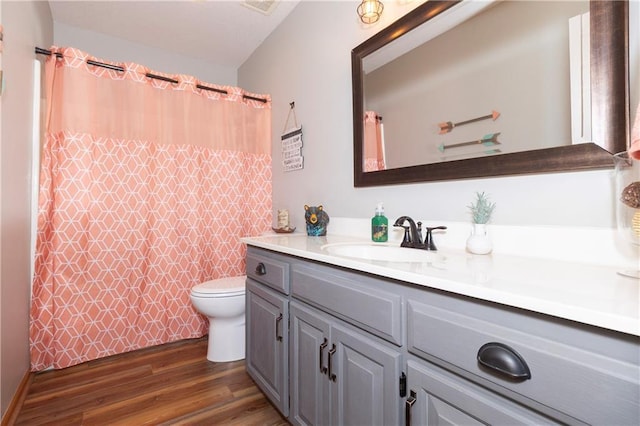 bathroom featuring a shower with curtain, toilet, wood finished floors, and vanity