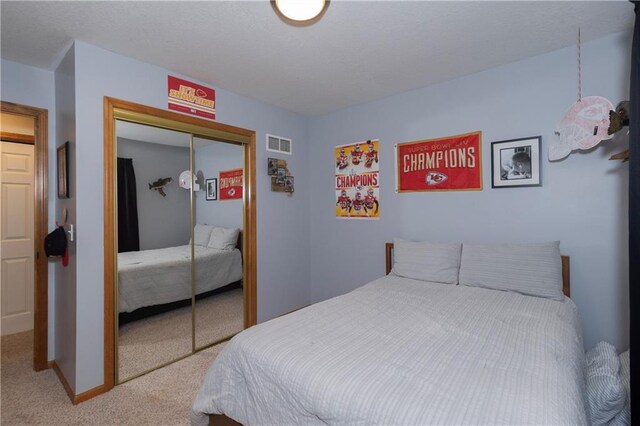 bedroom featuring carpet, visible vents, a closet, and baseboards