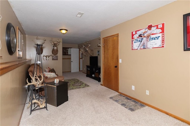 carpeted living area with a textured ceiling and baseboards