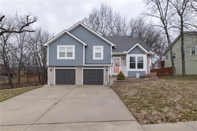 split level home with brick siding, concrete driveway, an attached garage, and fence