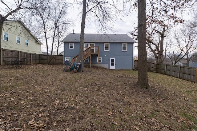 back of house featuring stairway and a fenced backyard