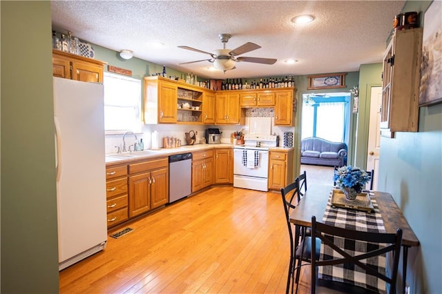 kitchen featuring ceiling fan, light wood-style flooring, white appliances, a sink, and open shelves