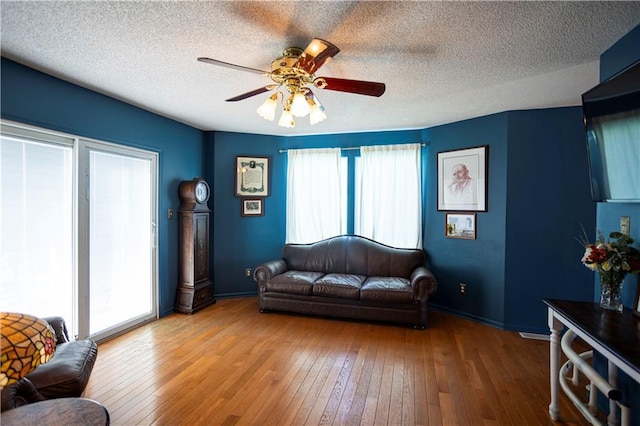 living room featuring a textured ceiling, hardwood / wood-style floors, and a healthy amount of sunlight