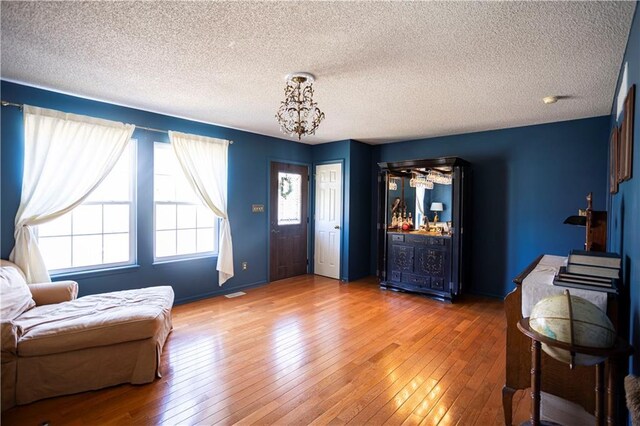 entryway featuring a textured ceiling, baseboards, and hardwood / wood-style flooring