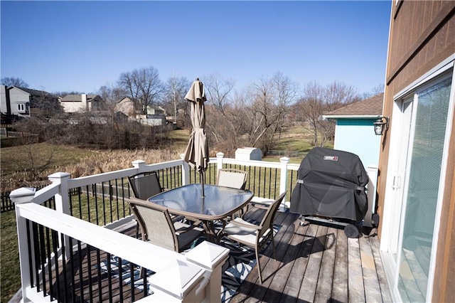 wooden terrace featuring outdoor dining space and grilling area