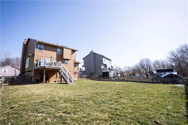 rear view of property featuring stairs, a deck, a lawn, and a fenced backyard