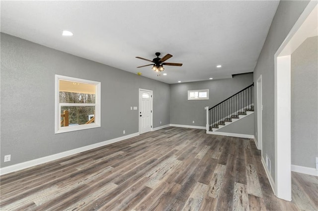 unfurnished living room with baseboards, stairway, recessed lighting, wood finished floors, and a ceiling fan