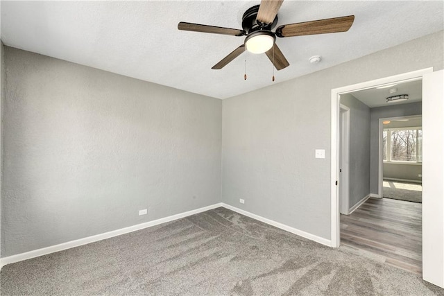 empty room featuring ceiling fan, a textured ceiling, baseboards, and carpet floors