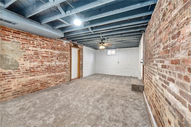 below grade area featuring brick wall, visible vents, and carpet floors