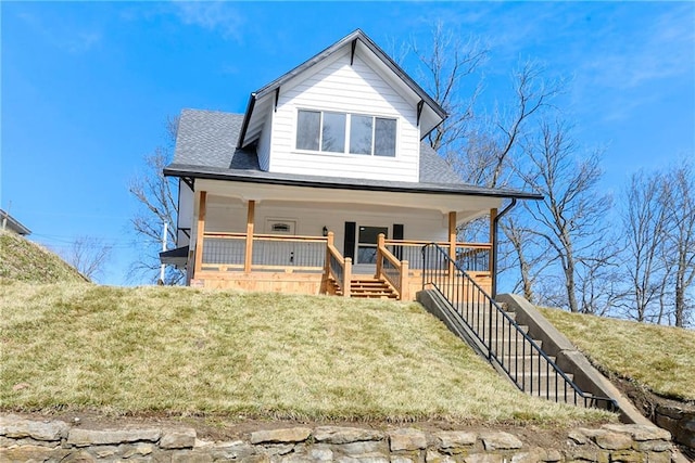 view of front of home featuring stairway, roof with shingles, a porch, and a front lawn