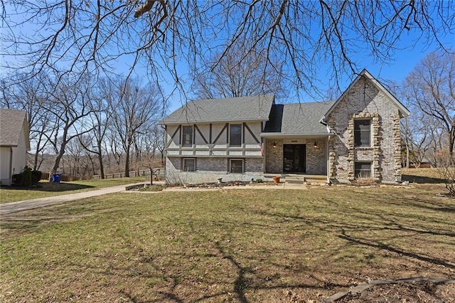 view of front of home with brick siding, a shingled roof, and a front yard