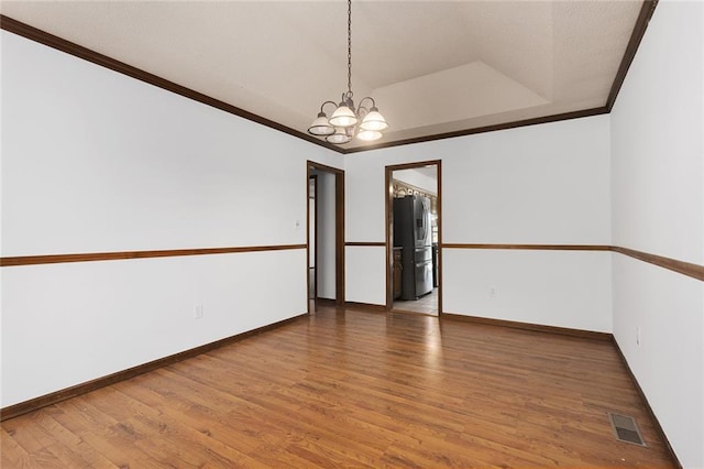 empty room featuring baseboards, visible vents, an inviting chandelier, crown molding, and light wood-type flooring