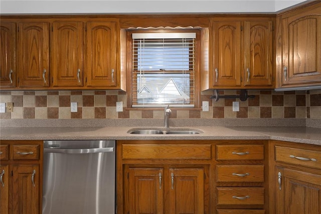 kitchen with brown cabinetry, a sink, light countertops, dishwasher, and tasteful backsplash