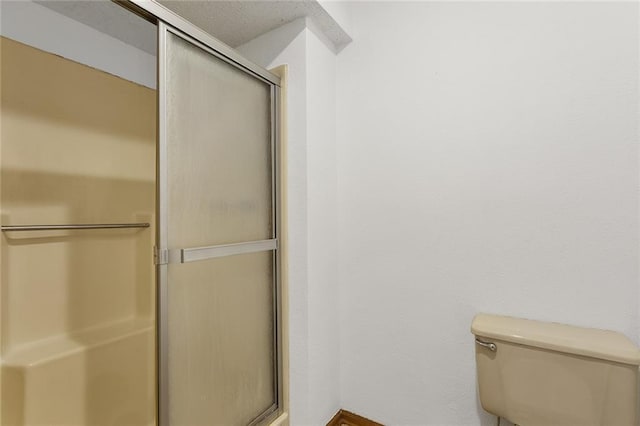 bathroom with a stall shower and toilet