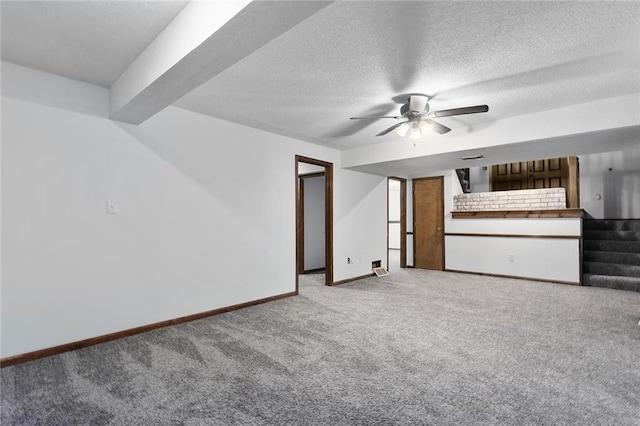 unfurnished living room featuring baseboards, stairs, carpet flooring, a textured ceiling, and a ceiling fan