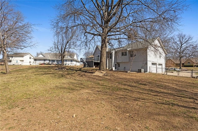 view of yard with a wooden deck, a residential view, stairs, and fence