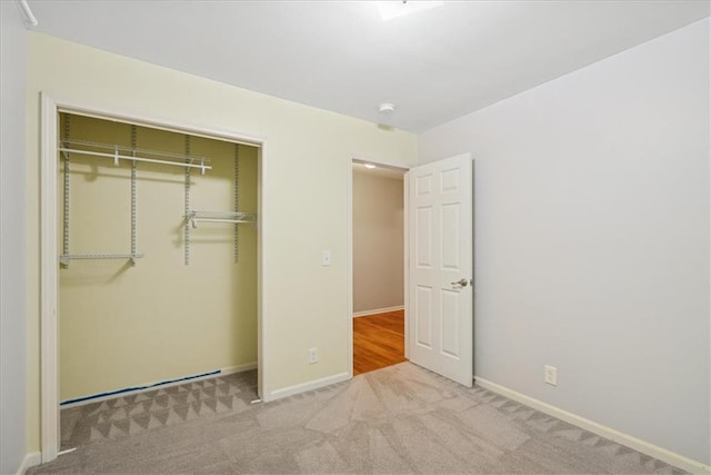 unfurnished bedroom featuring carpet flooring, baseboards, and a closet