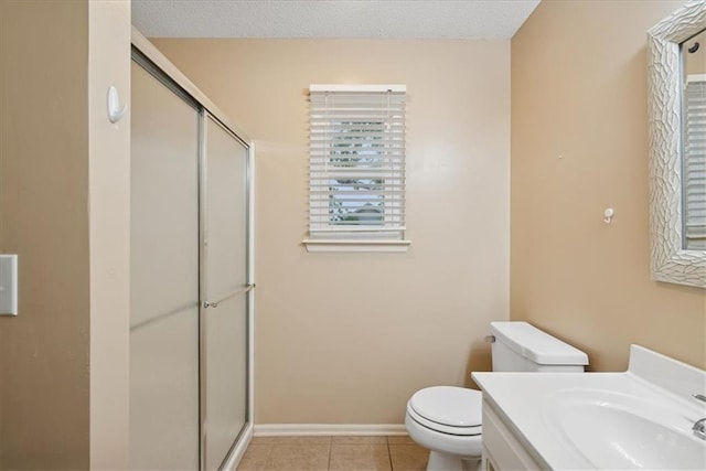 full bath featuring tile patterned flooring, vanity, toilet, baseboards, and a stall shower