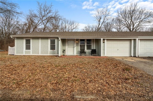 single story home featuring a garage, covered porch, and driveway