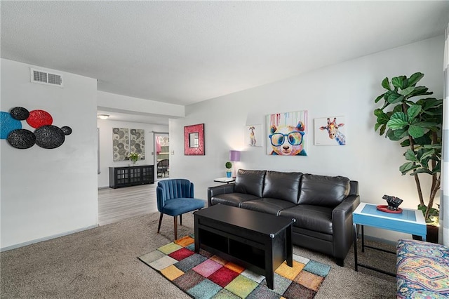 living area with baseboards, visible vents, and carpet floors