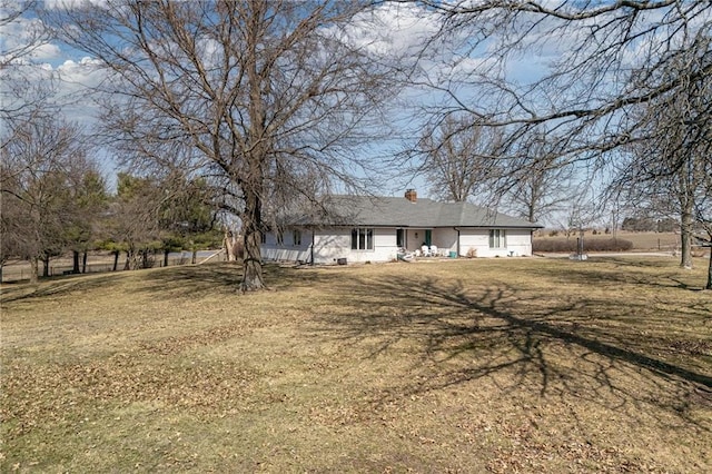 view of front of house with a front yard and a chimney