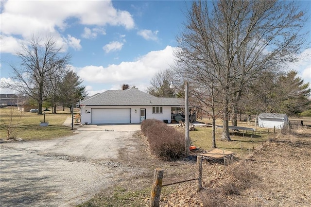 view of front of home with a front yard, an attached garage, fence, and driveway