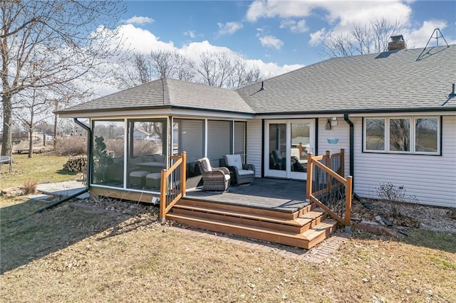 back of house featuring a shingled roof, a trampoline, a wooden deck, a chimney, and a sunroom