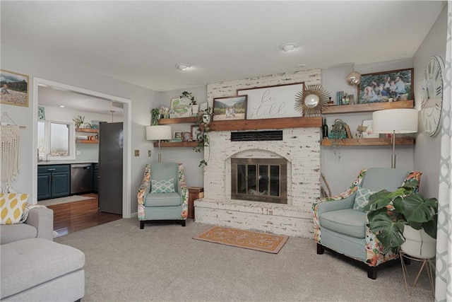 carpeted living area with a fireplace and a sink