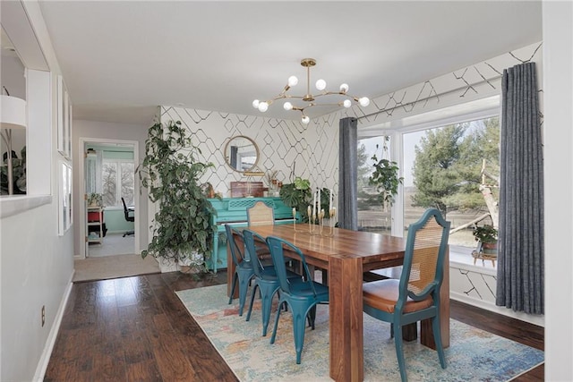 dining space featuring a wealth of natural light, a notable chandelier, wood finished floors, and wallpapered walls