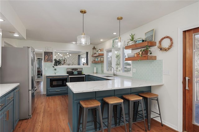 kitchen with open shelves, a peninsula, a sink, stainless steel appliances, and light wood-style floors