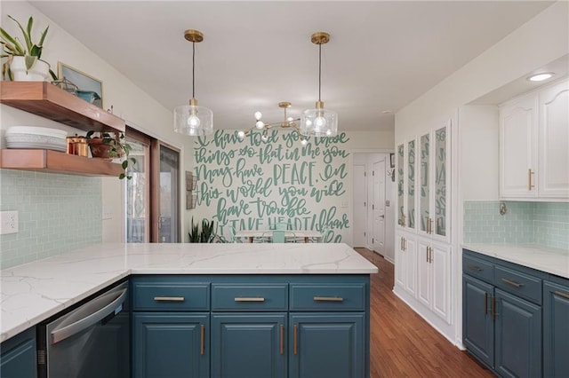 kitchen featuring blue cabinets, stainless steel dishwasher, a peninsula, and white cabinets