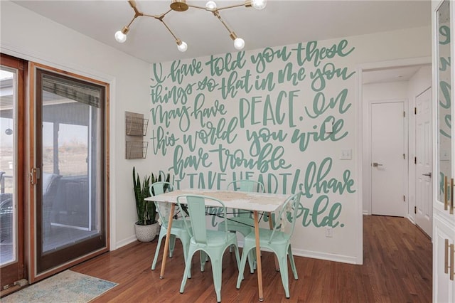 dining room with baseboards, an inviting chandelier, and wood finished floors