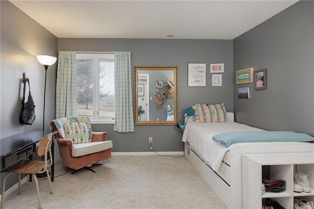 bedroom with light carpet, a textured ceiling, and baseboards