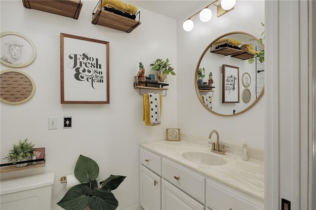 half bath featuring vanity and toilet