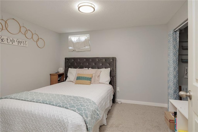 bedroom with carpet, baseboards, and a textured ceiling