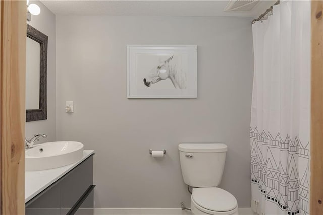 bathroom featuring visible vents, toilet, and vanity