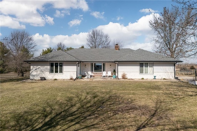 single story home featuring a chimney and a front lawn