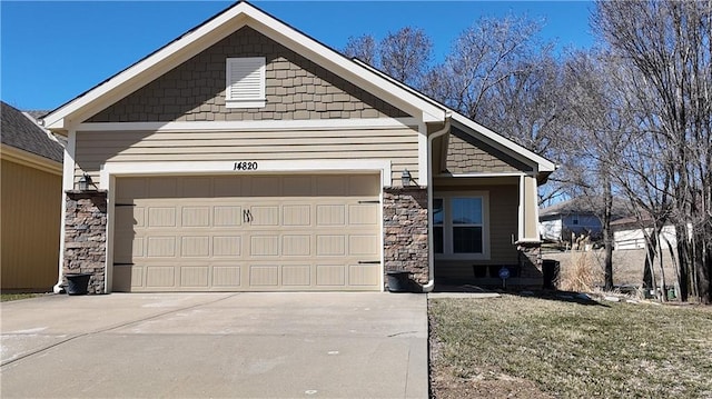 view of front of property with stone siding, driveway, and an attached garage