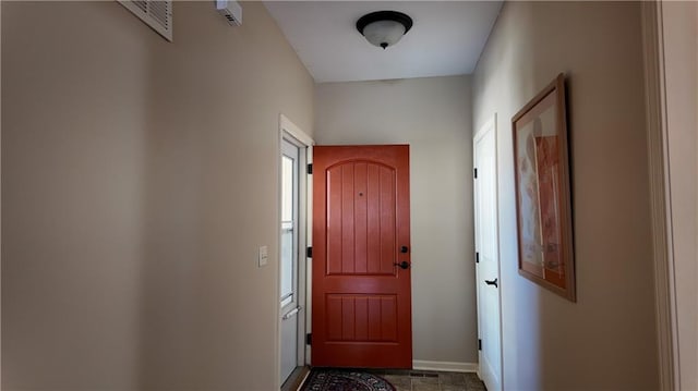 doorway with visible vents and baseboards