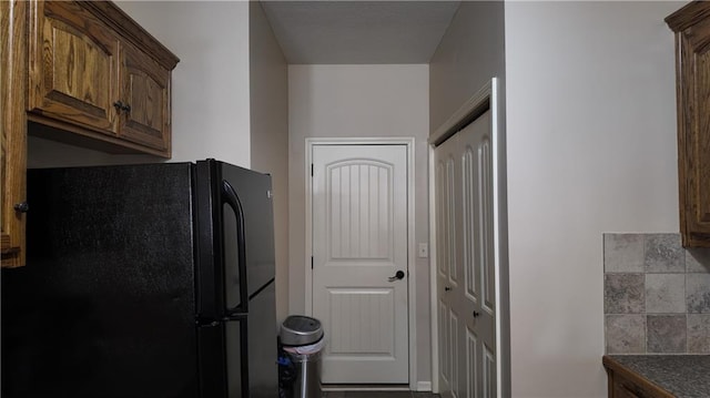 kitchen featuring dark countertops and freestanding refrigerator