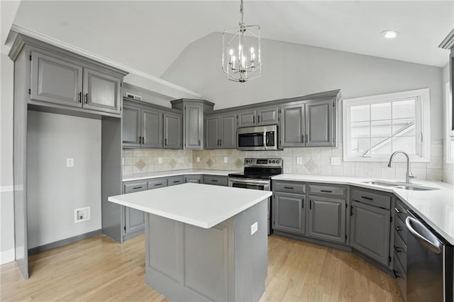12203 E 214th Ter, Peculiar, MO 64078 - kitchen featuring stainless steel appliances, gray cabinets, a sink, lofted ceiling, and a chandelier