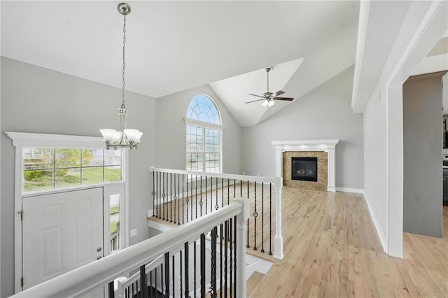 12203 E 214th Ter, Peculiar, MO 64078 - hallway with an upstairs landing, light wood-type flooring, a chandelier, vaulted ceiling, and baseboards