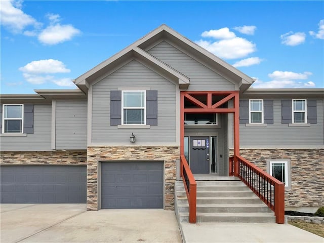 view of front of property with a garage, stone siding, and concrete driveway