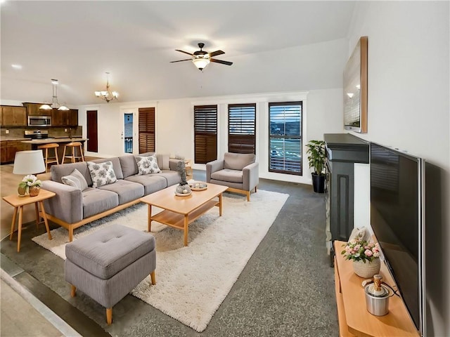 living room featuring ceiling fan with notable chandelier and dark carpet