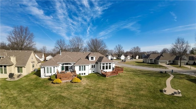 back of property with a yard, a residential view, and a wooden deck