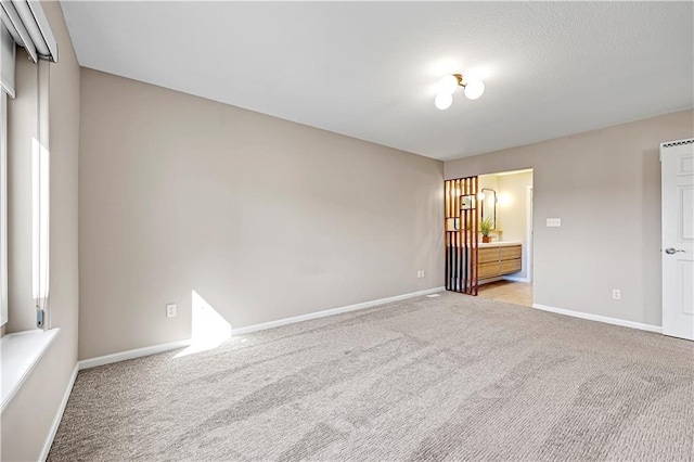 unfurnished bedroom with light colored carpet and baseboards