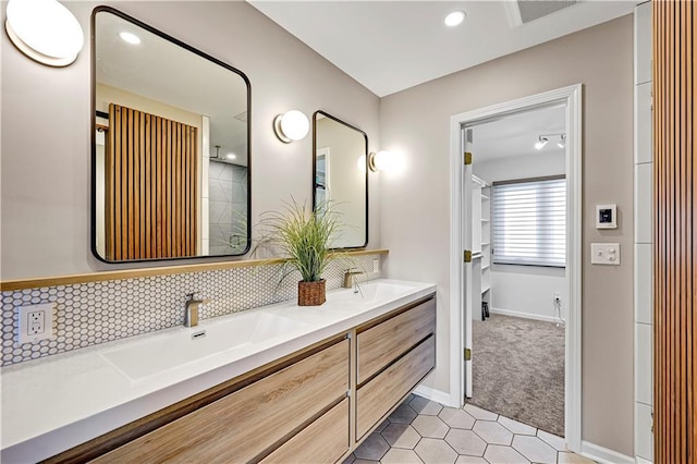 bathroom featuring double vanity, decorative backsplash, visible vents, and a sink