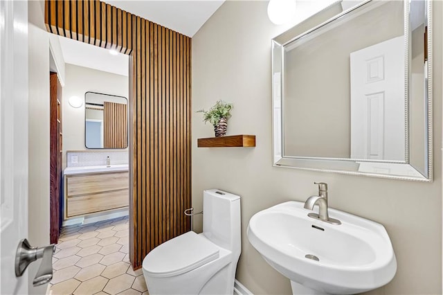 bathroom featuring tile patterned floors, toilet, and a sink