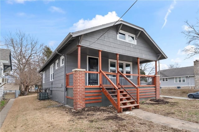 bungalow-style house featuring a porch and central AC